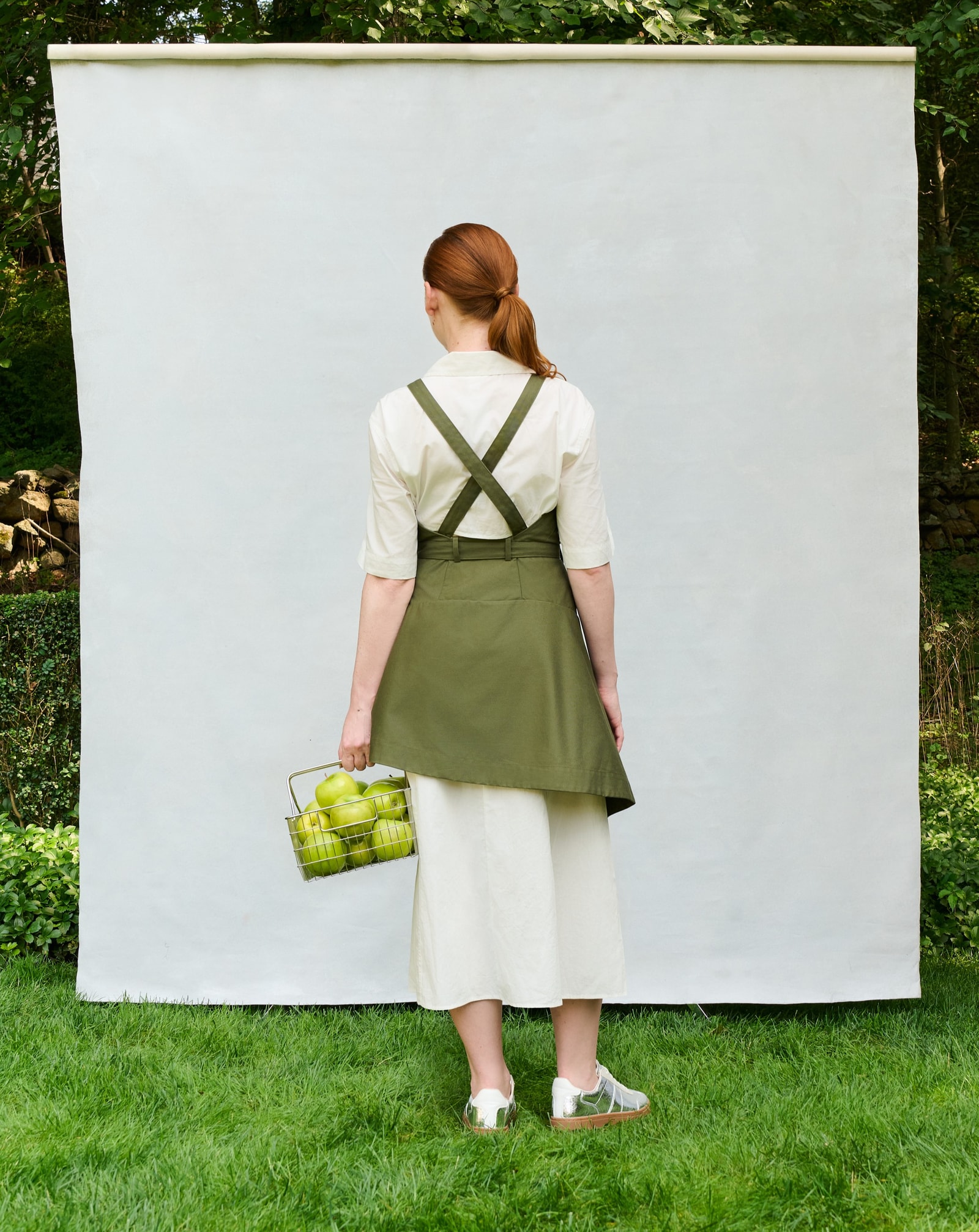 Model wearing the olive Trigo Apron, back view.